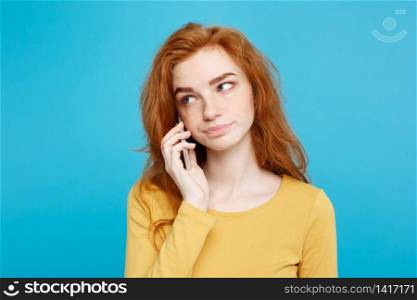 Lifestyle and Technology concept - Portrait of cheerful happy ginger red hair girl with shocking and stressful expression while talking with friend by mobile phone. Isolated on Blue Pastel Background. Copy space.. Lifestyle and Technology concept - Portrait of ginger red hair girl with shocking and stressful expression while talking with friend by mobile phone. Isolated on Blue Pastel Background. Copy space.