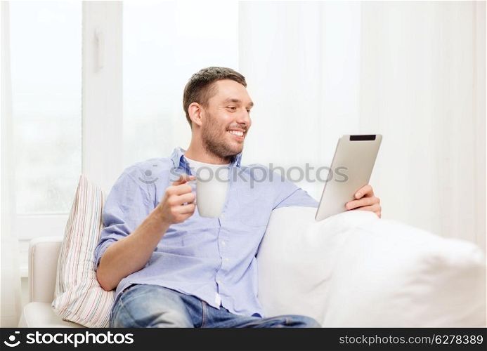 lifestyle and technology concept - smiling man working with tablet pc at home