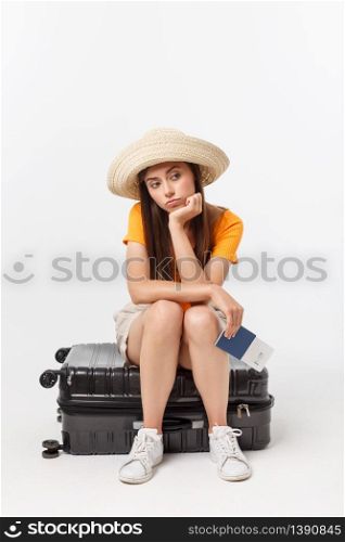 Lifestyle and travel Concept: Young beautiful caucasian woman is sitting on suitecase and waiting for her flight.Isolated over white background.. Lifestyle and travel Concept: Young beautiful caucasian woman is sitting on suitecase and waiting for her flight.Isolated over white background