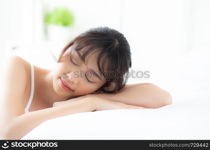 Lifestyle beautiful portrait young asian woman relax lying sleep and smile while wake up with sunrise at morning, girl with happy and fun in the bedroom, health and wellness concept.