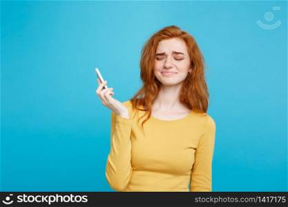 Lifestyle concept - Portrait of a shocked surprised girl in yellow dress talking on mobile phone. Isolated on Blue Pastel Background. Copy space.. Lifestyle and Technology concept - Portrait of cheerful happy ginger red hair girl with joyful and exciting smiling to camera. Isolated on Blue Pastel Background. Copy space.