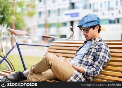 lifestyle, creativity, freelance, inspiration and people concept - creative man with notebook or diary writing sitting on city street bench
