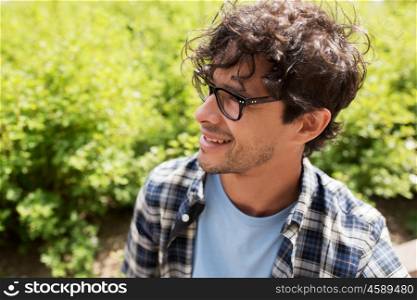 lifestyle, emotion, expression and people concept - close up of happy smiling man in eyeglasses outdoors