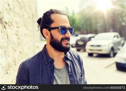 lifestyle, emotion, expression and people concept - happy smiling man with beard and sunglasses on city street. happy smiling man with beard on city street. happy smiling man with beard on city street