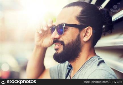 lifestyle, emotion, expression and people concept - happy smiling man with sunglasses and beard on city street. happy smiling man with beard on city street. happy smiling man with beard on city street