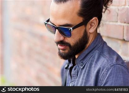 lifestyle, emotion, expression and people concept - man with beard and sunglasses on city street