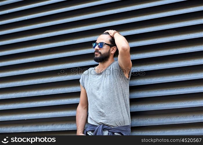 lifestyle, emotion, expression and people concept - man with sunglasses and beard on city street