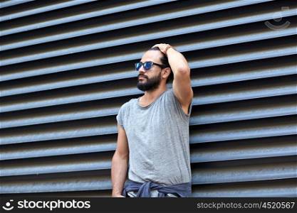 lifestyle, emotion, expression and people concept - man with sunglasses and beard on city street