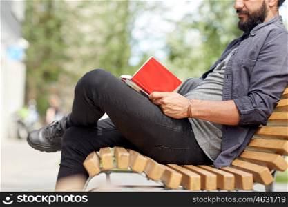 lifestyle, freelance, inspiration and people concept - close up of man writing to notebook or diary sitting on city street bench