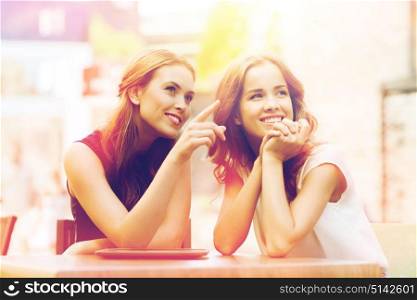 lifestyle, friendship and people concept - happy young women or teenage girls with tablet pc at cafe outdoors. happy young women or teenage girls with tablet pc