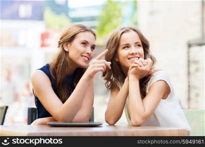 lifestyle, friendship and people concept - happy young women or teenage girls with tablet pc at cafe outdoors