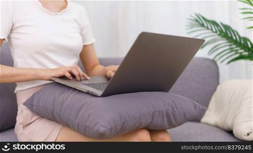 Lifestyle in living room concept, Asian woman sit on couch and using laptop to surfing social media.