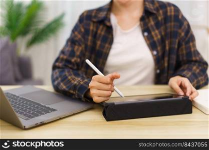 Lifestyle in living room concept, Young Asian woman using laptop and taking notes data on tablet.