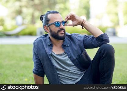 lifestyle, leisure and people concept - man in sunglasses at city street or park