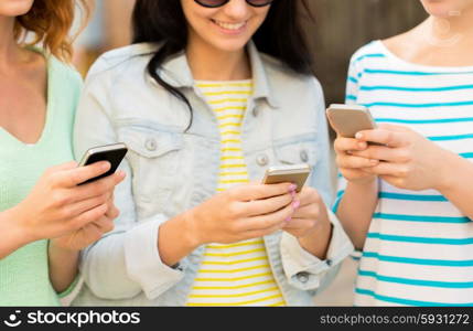 lifestyle, leisure, technology and people concept - close up of happy young women with smartphone outdoors