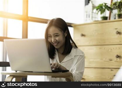 Lifestyle of Beautiful Attractive Asian woman smile working or shopping online with computer laptop in bedroom feeling so happiness and cheerful,Relax in holiday with laptop and using social network