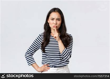Lifestyle, people emotions and casual concept. Angry serious young asian woman scolding person being loud, shush with mad face and index finger pressed to lips, tell be quiet.. Lifestyle, people emotions and casual concept. Angry serious young asian woman scolding person being loud, shush with mad face and index finger pressed to lips, tell be quiet