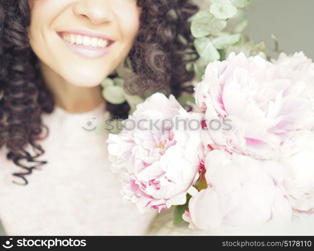 Lifestyle photo of beautiful smiling woman with pink peonies. Bouquet as gift. Emotions of happiness and joy