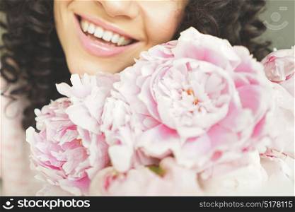 Lifestyle photo of beautiful smiling woman with pink peonies. Bouquet as gift. Emotions of happiness and joy