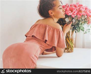 Lifestyle photo of beautiful young woman with pink peonies. Bouquet as gift. Emotions of happiness and joy. Valentines day. Mothers day