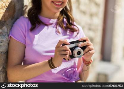 lifestyle, photography and people concept - close up of smiling teenage girl or young woman with vintage camera outdoors. close up of woman with vintage camera outdoors