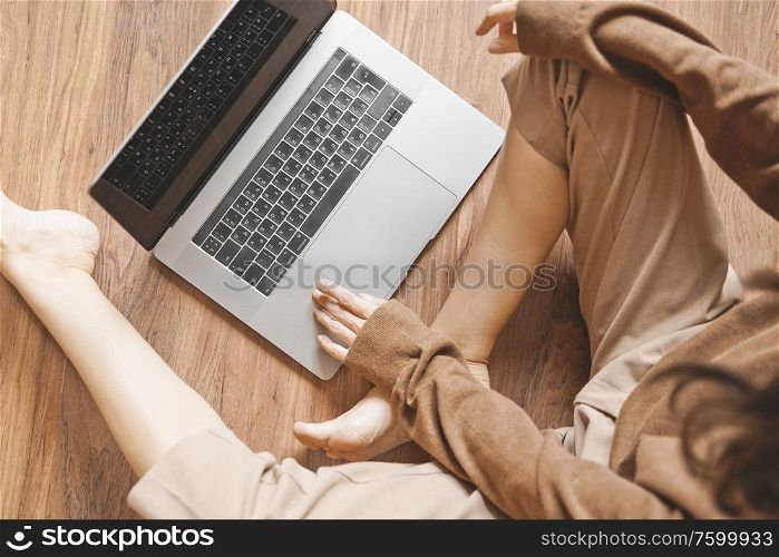 Lifestyle portrait of beautiful lady working at notebook sitting down on floor at home. Woman concept for alternative office freelance. Stay home