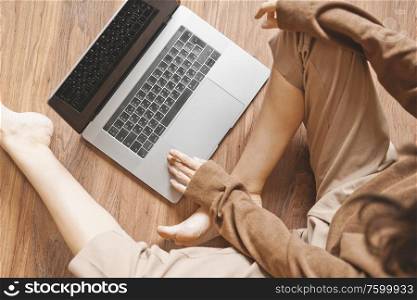 Lifestyle portrait of beautiful lady working at notebook sitting down on floor at home. Woman concept for alternative office freelance. Stay home
