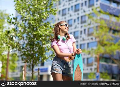 lifestyle, summer and people concept - smiling young woman or teenage girl in sunglasses with longboard on city street. happy teenage girl in shades with longboard