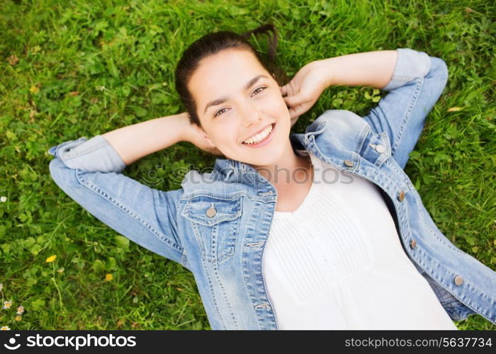 lifestyle, summer vacation, leisure and people concept - smiling young girl in blank white shirt lying on grass