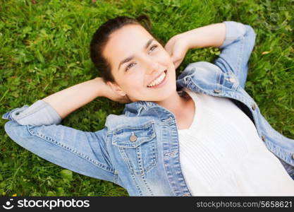 lifestyle, summer vacation, leisure and people concept - smiling young girl in blank white shirt lying on grass
