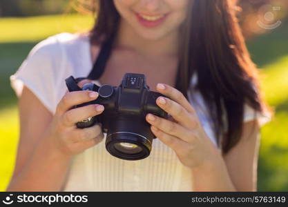 lifestyle, summer, vacation, technology and people concept - close up of young girl with photo camera outdoors