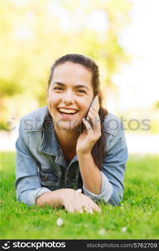 lifestyle, summer vacation, technology, leisure and people concept - laughing young girl with smartphone talking and lying on grass in park