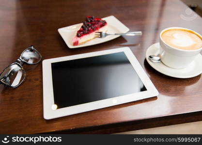 lifestyle, technology and object concept - close up of tablet pc computer, eyeglasses, coffee cup and berry cake on table