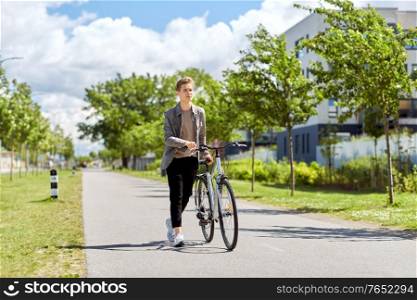 lifestyle, transport and people concept - young man or teenage boy with bicycle walking along city street. young man with bicycle walking along city street