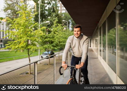 lifestyle, transport and people concept - young man riding bicycle on city street