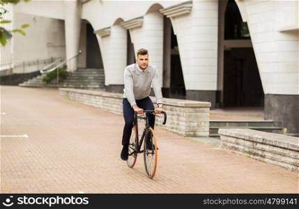 lifestyle, transport and people concept - young man riding bicycle on city street