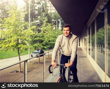 lifestyle, transport and people concept - young man riding bicycle on city street. young man riding bicycle on city street