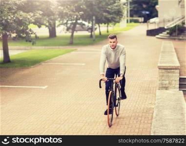 lifestyle, transport and people concept - young man riding bicycle on city street. young man riding bicycle on city street