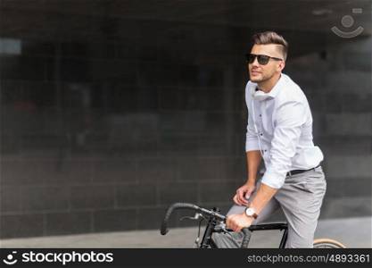lifestyle, transport and people concept - young man with bicycle and headphones on city street