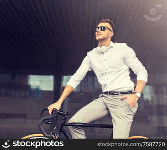 lifestyle, transport and people concept - young man with bicycle and headphones on city street. man with bicycle and headphones on city street