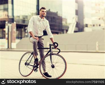 lifestyle, transport and people concept - young man with bicycle and headphones on city street. man with bicycle and headphones on city street
