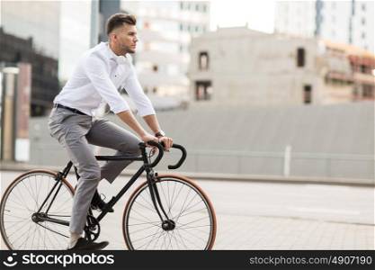 lifestyle, transport and people concept - young man with headphones riding bicycle on city street. man with headphones riding bicycle on city street