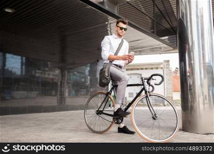 lifestyle, transport, communication and people concept - young man with bicycle and smartphone on city street