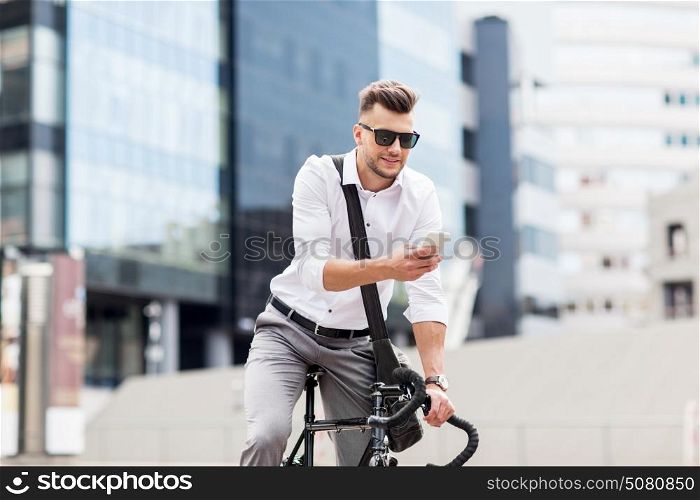 lifestyle, transport, communication and people concept - young man with bicycle and smartphone on city street. man with bicycle and smartphone on city street