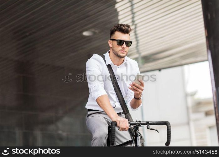 lifestyle, transport, communication and people concept - young man with bicycle and smartphone on city street. man with bicycle and smartphone on city street