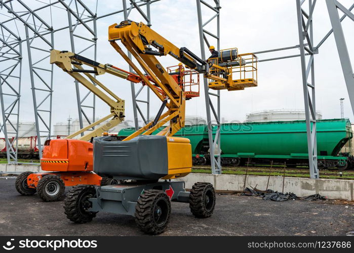 Lift with platform work in warehouse hangar construction field.