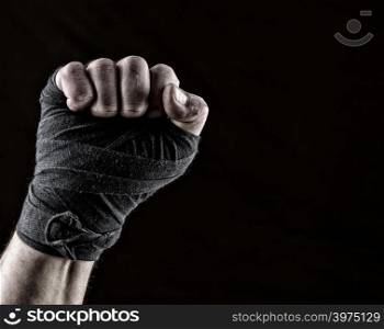 lifted up fist of athlete wrapped in black textile bandage, gesture of solidarity