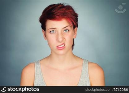 lifting one side of her lip and eyebrow. young redhead woman lifting one side of her lip and eyebrow