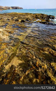 light beach boat yacht in lanzarote spain coastline rock water and summer