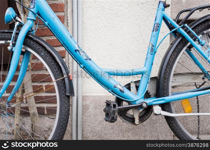Light Blue Bicycle lent against Brick Wall